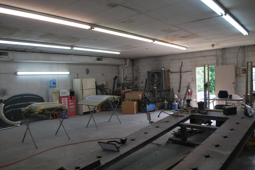Parts of cars on racks to be painted.